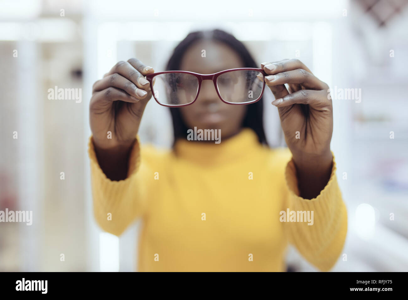 Young african woman pointed eyeglasses frames in Optical Store. Cute