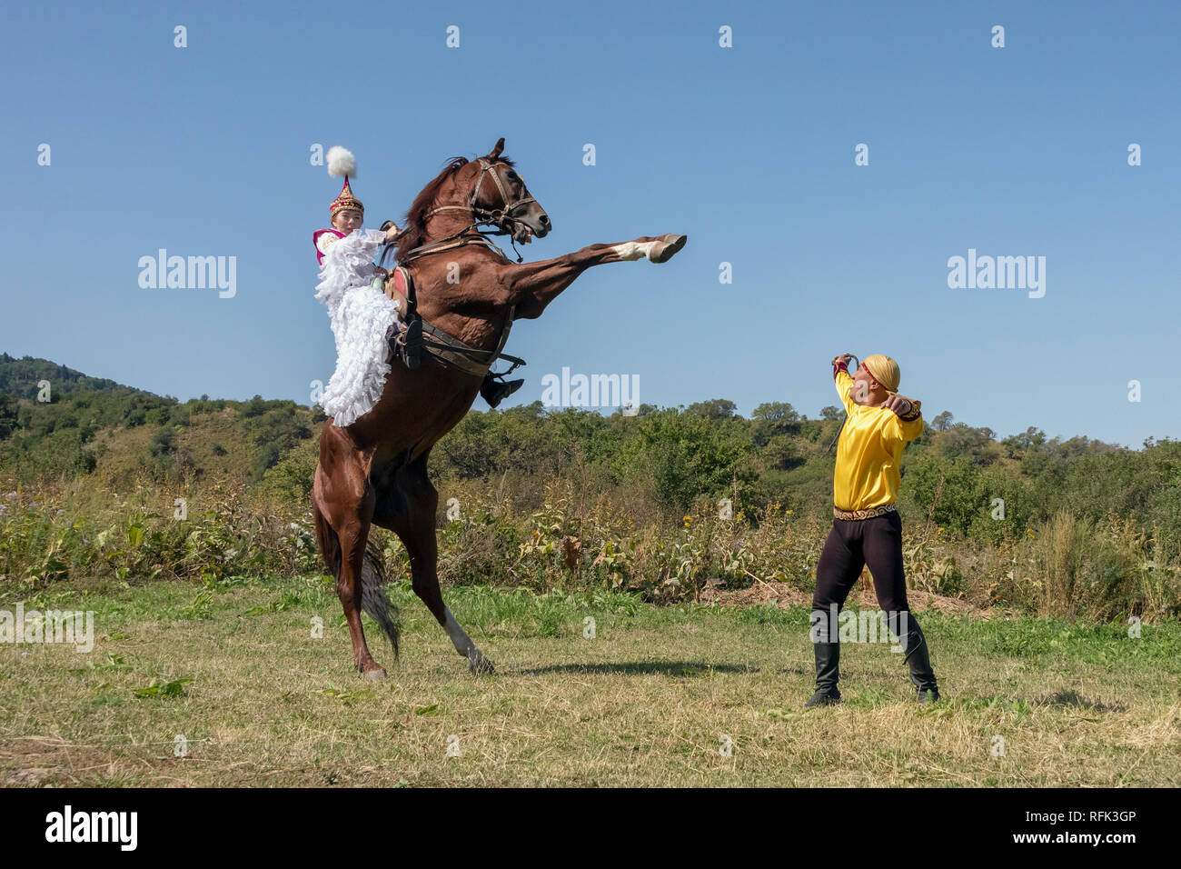 Kazakh woman in traditional attire on a rearing horse, Almaty, Kazakhstan Stock Photo