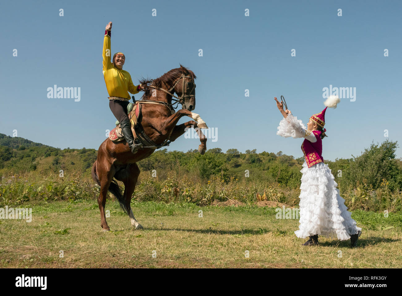 Kazakh man and woman teaming up with rearing horse, Almaty Kazakhstan Stock Photo