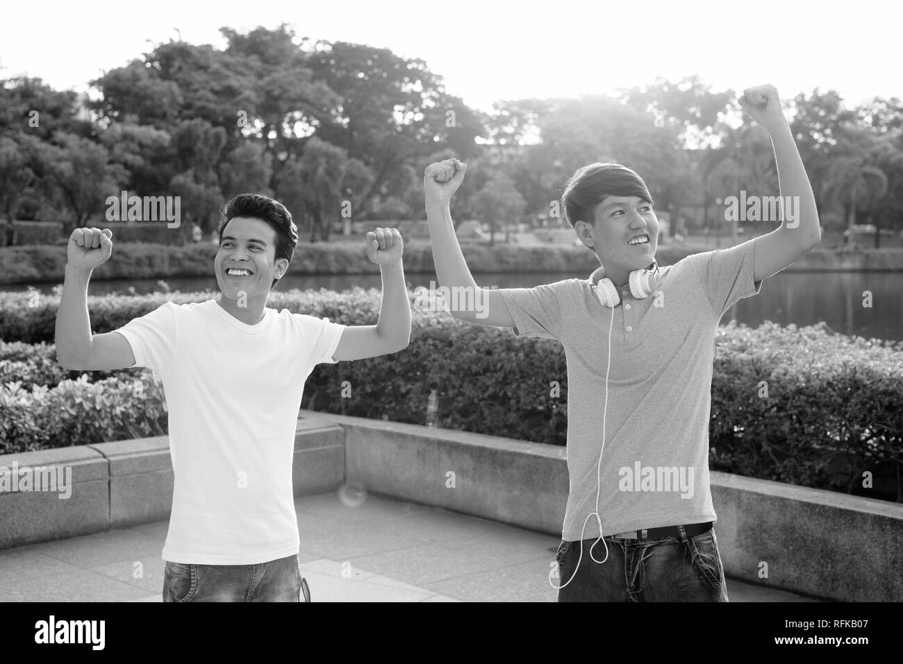 Young Asian man and young Asian teenage boy at the park together Stock Photo