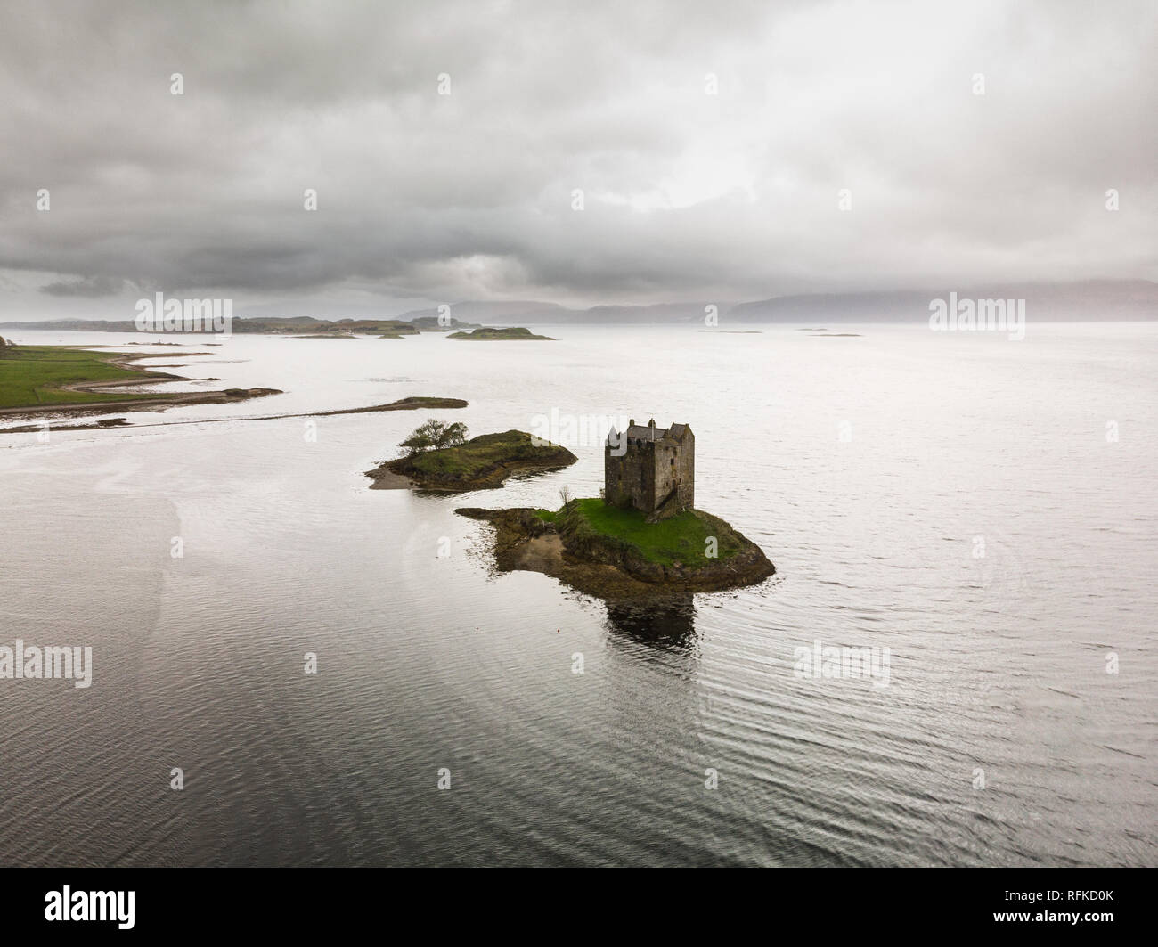 Aerial view of Castle Stalker in Loch Linnhe during a rainy autumn day with moody sky (Castle Stalker, Scotland, United Kingdom, Europe) Stock Photo