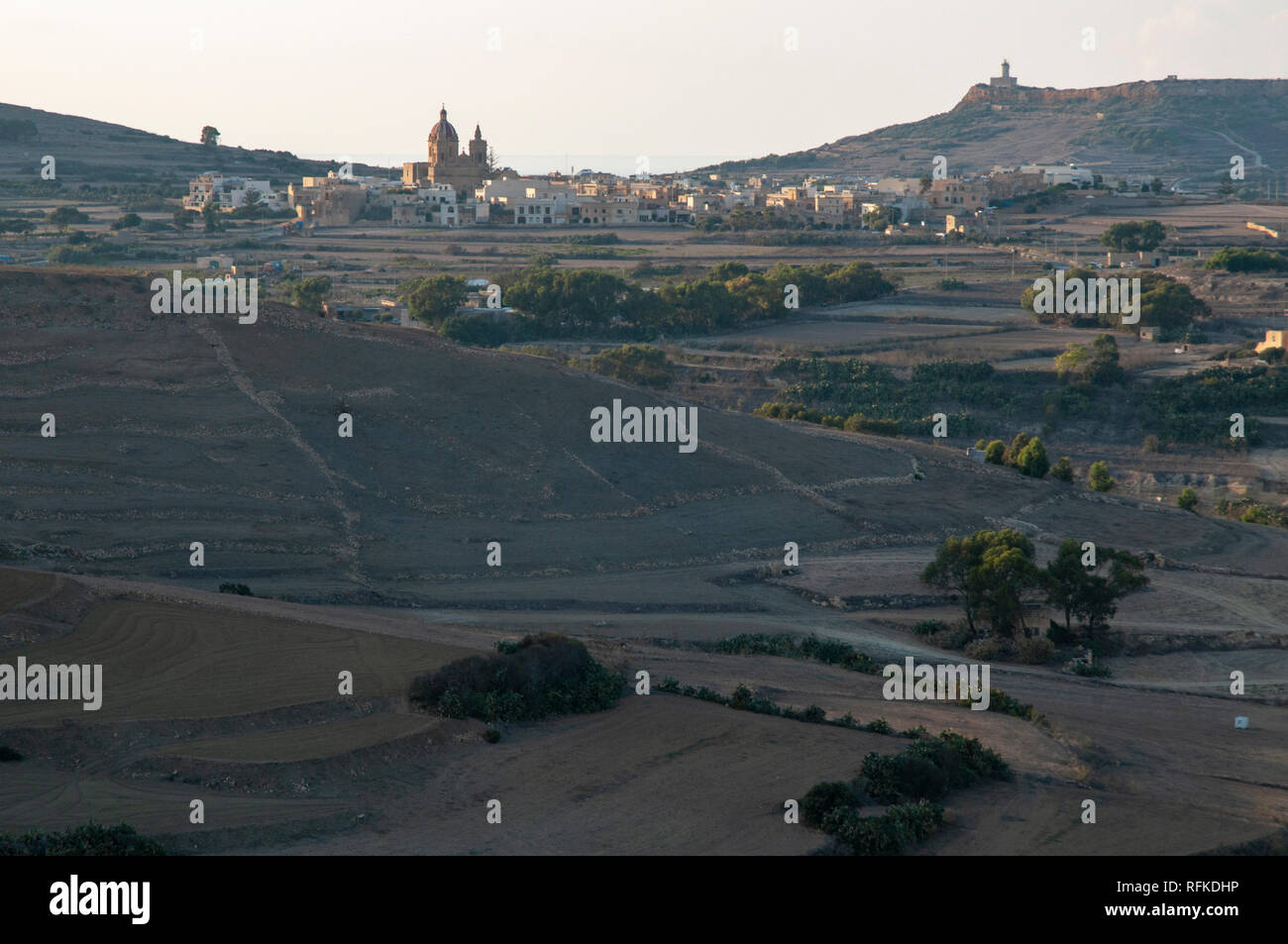 View to the village of Ghasri and the prominent landmark of Corpus Christi Church with surrounding landscape on Gozo in Malta. Shot from the Citadella. Stock Photo