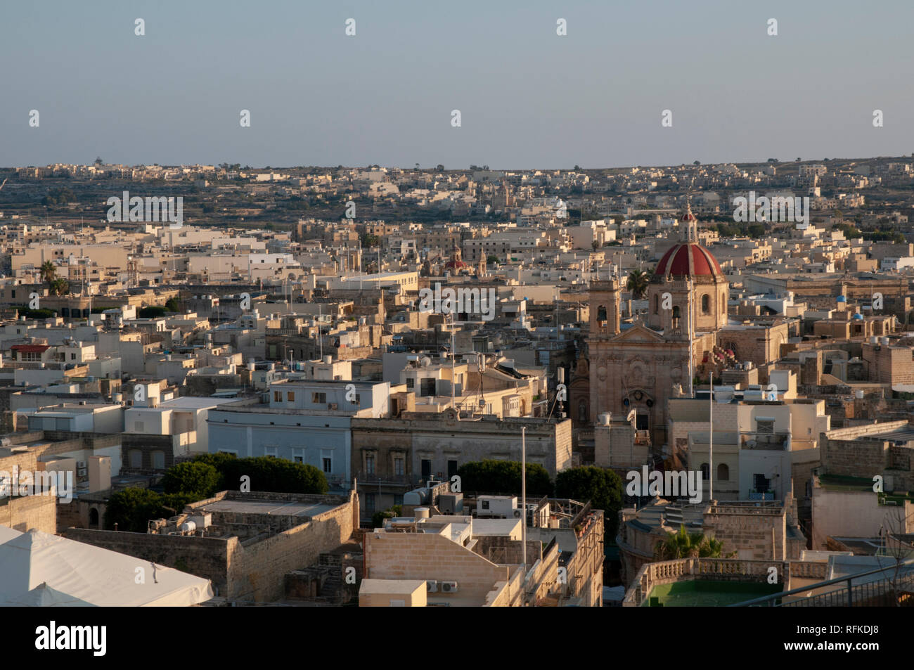 View from the Citadella of rooftops of Victoria, the capital on the island of Gozo in Malta. St George's Basilica is a prominent landmark. Stock Photo