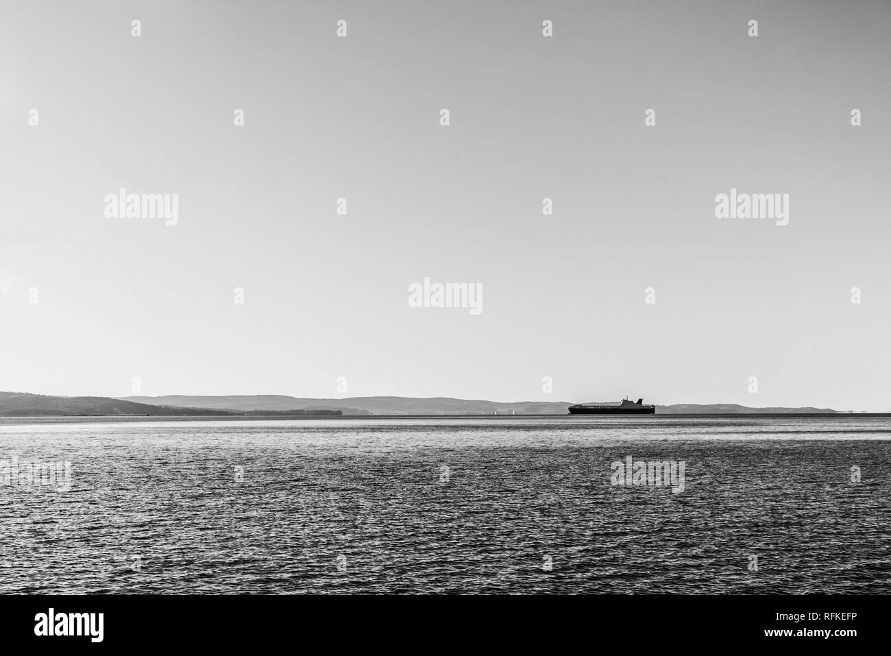 Ship is delivering cargo on a clear day. Stock Photo