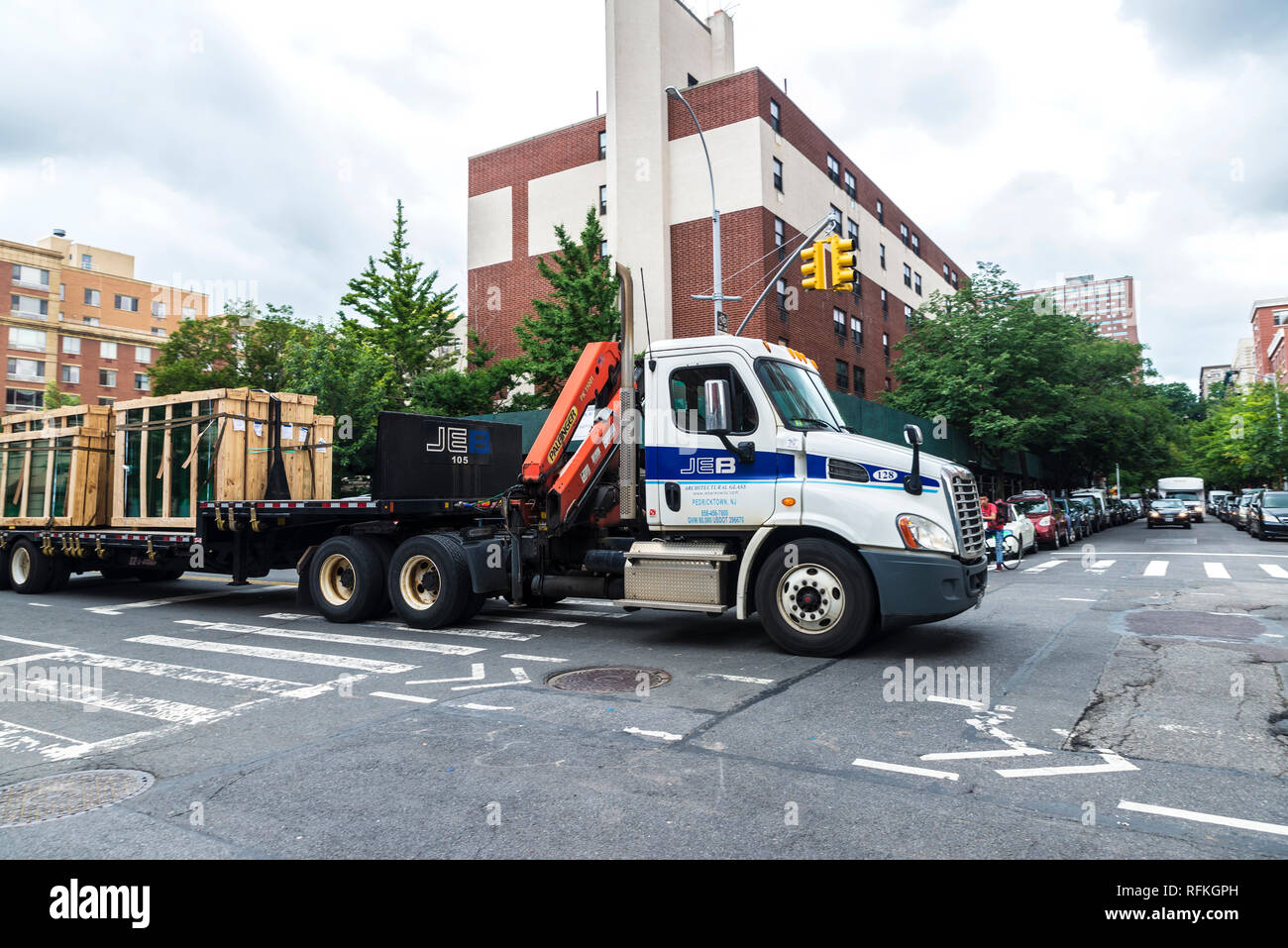 New York City, USA - July 26, 2018: Heavy truck transporting window glass with people around in Harlem, Manhattan, New York City, USA Stock Photo