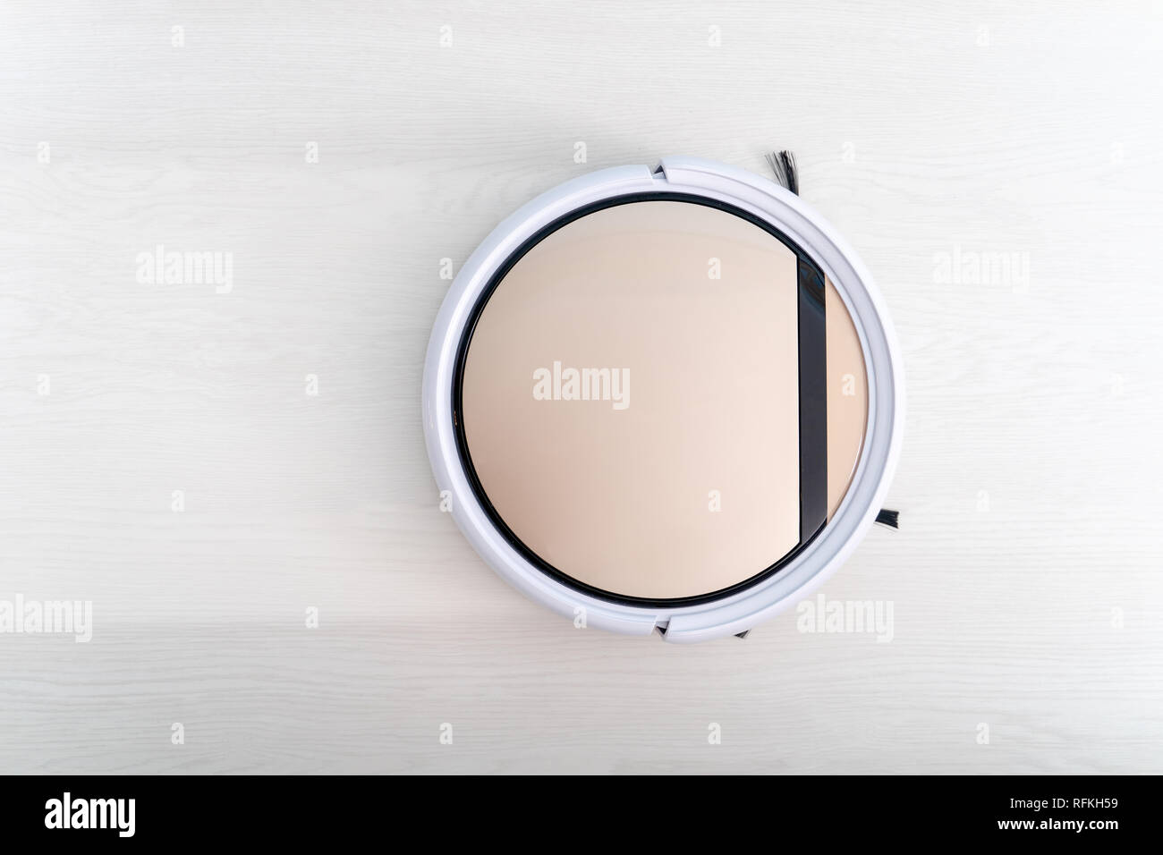 Robotic vacuum cleaner cleaning laminate wood floor Stock Photo Alamy