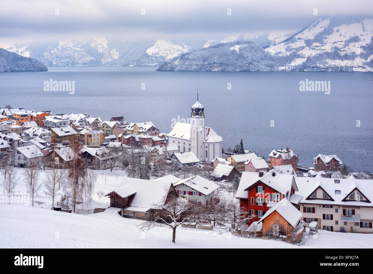 Beckenried village on Lake Lucerne, swiss Alps mountains, Switzerland, covered with white snow in winter time Stock Photo