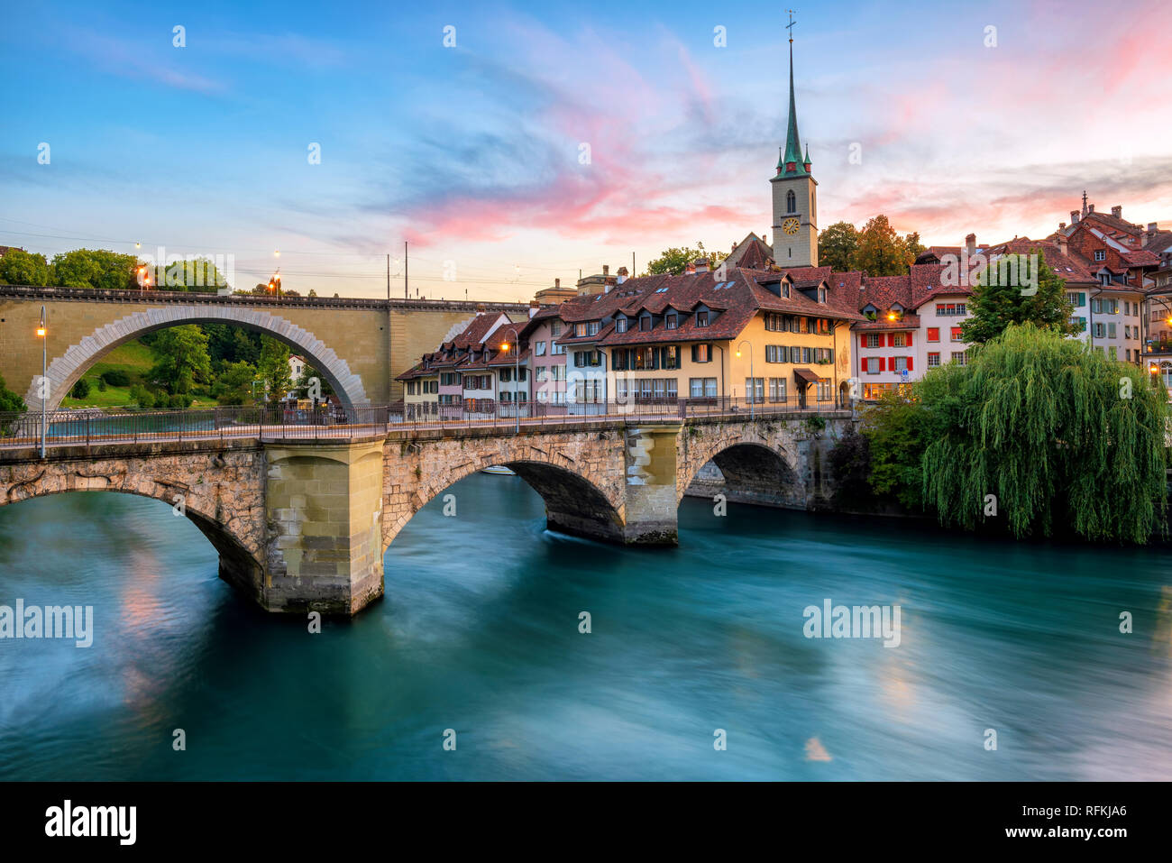 Historical Old Town of Bern city, tiled roofs, bridges over Aare river and church tower on dramatic sunset, Switzerland Stock Photo