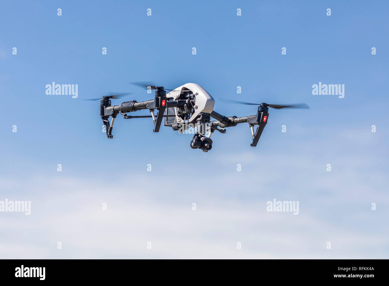 Unmanned Aerial Vehicle (UAV) or drone flying silhouetted above the ...