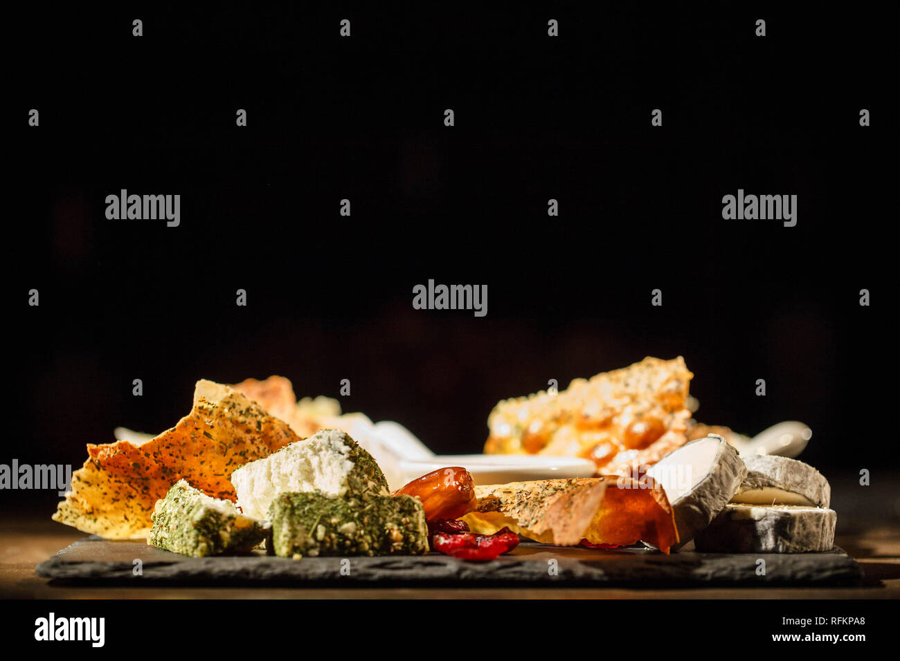Different kinds of cheese lie on black plate Stock Photo