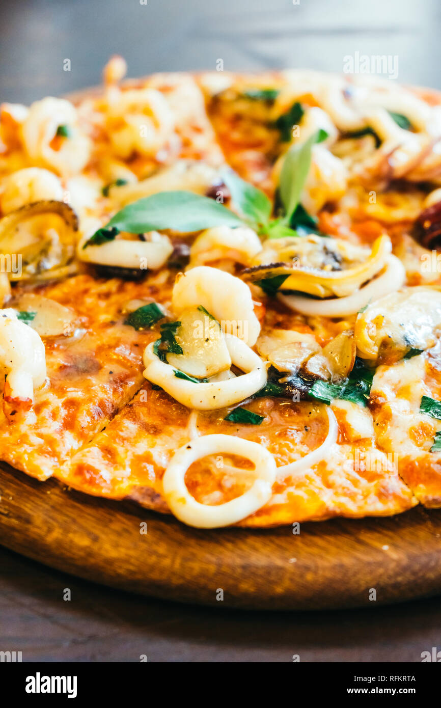 Spicy seafood pizza on wooden tray - Unhealthy food style , Color Filter Processing Stock Photo