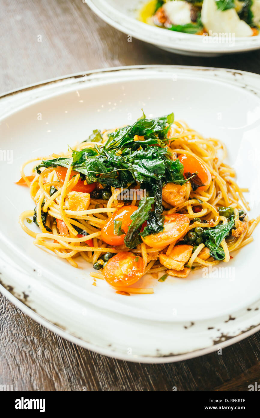 Spicy spaghetti and pasta with salmon and basil leaf on top in white plate  - Italian food style , Color filter Processing Stock Photo - Alamy