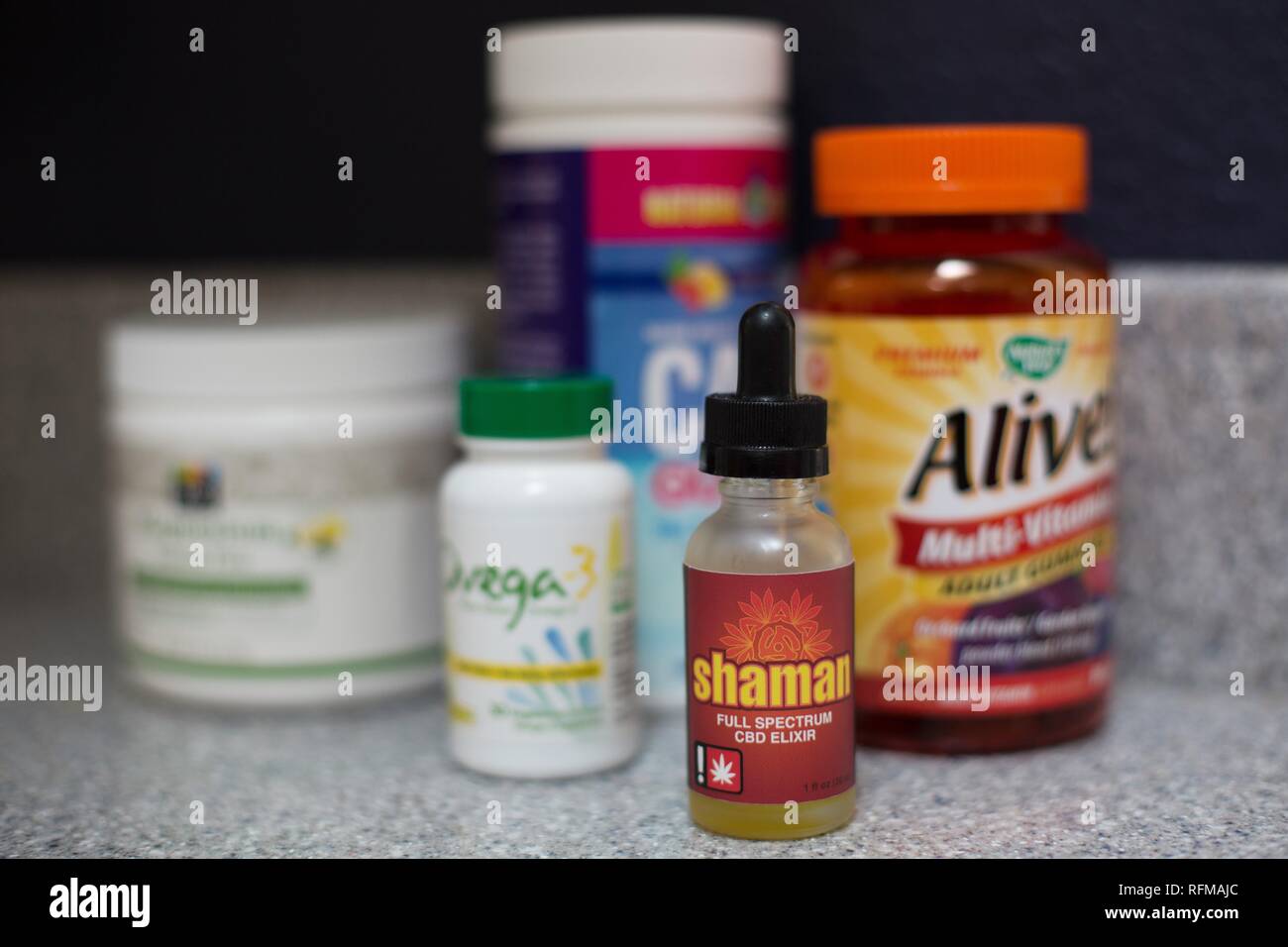 A bottle of CBD oil next to vitamins and supplements. Stock Photo