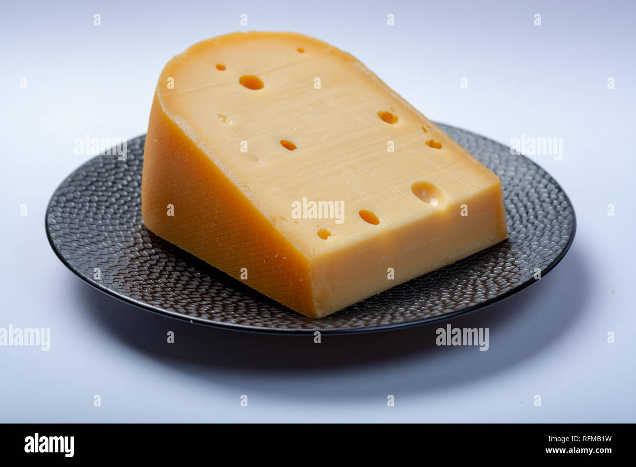 One piece of traditional Dutch old hard cheese made from cow milk close ...