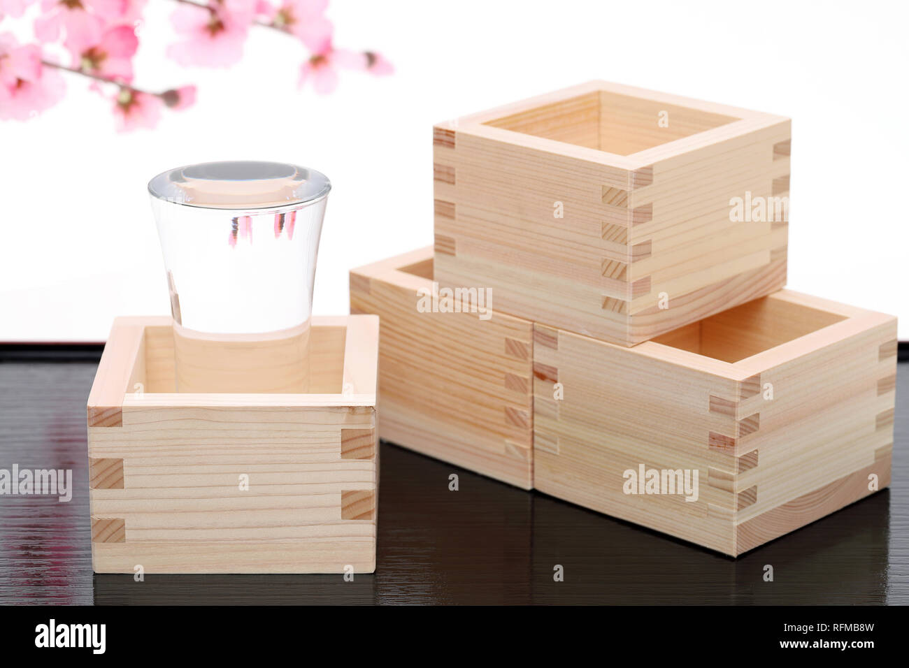 Japanese wooden box masu with sake isolated on white background Stock