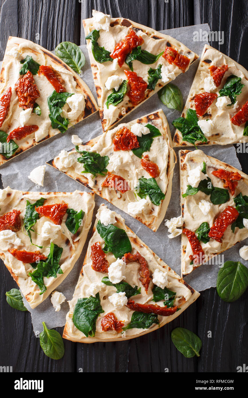 Freshly baked flatbread with hummus, sundried tomatoes, spinach and