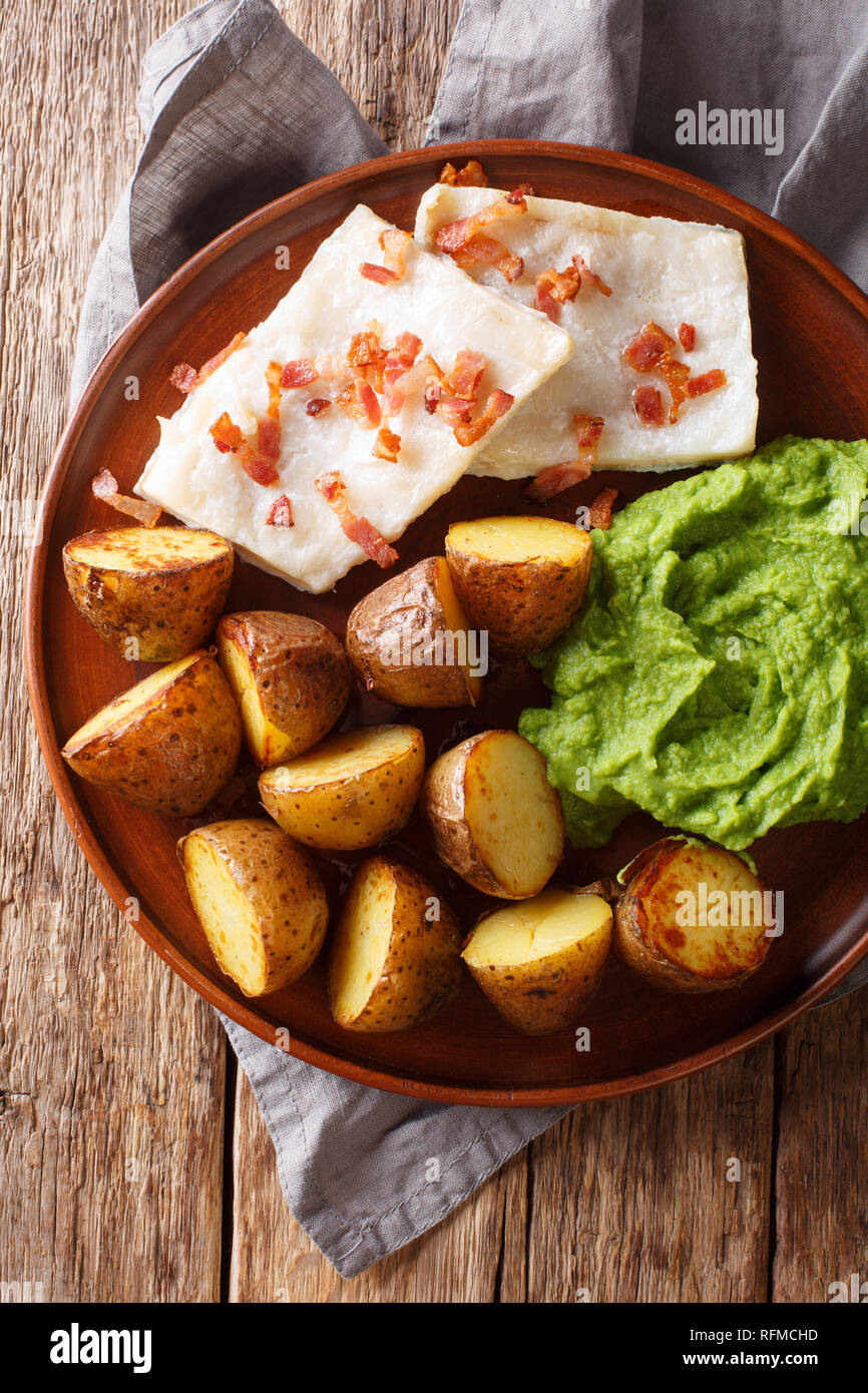 Norwegian cod lutefisk served with pea puree, potatoes and bacon close