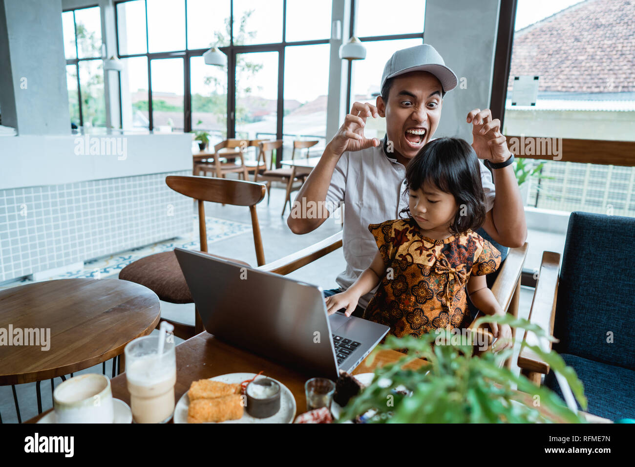 child disturb her dad while working Stock Photo