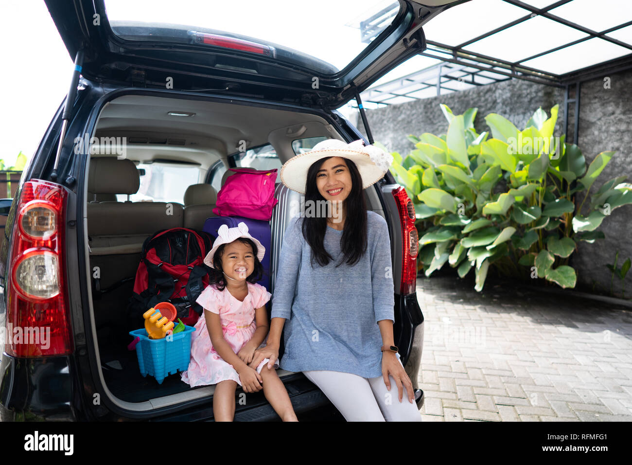 mother and child sitting in the car trunk Stock Photo - Alamy