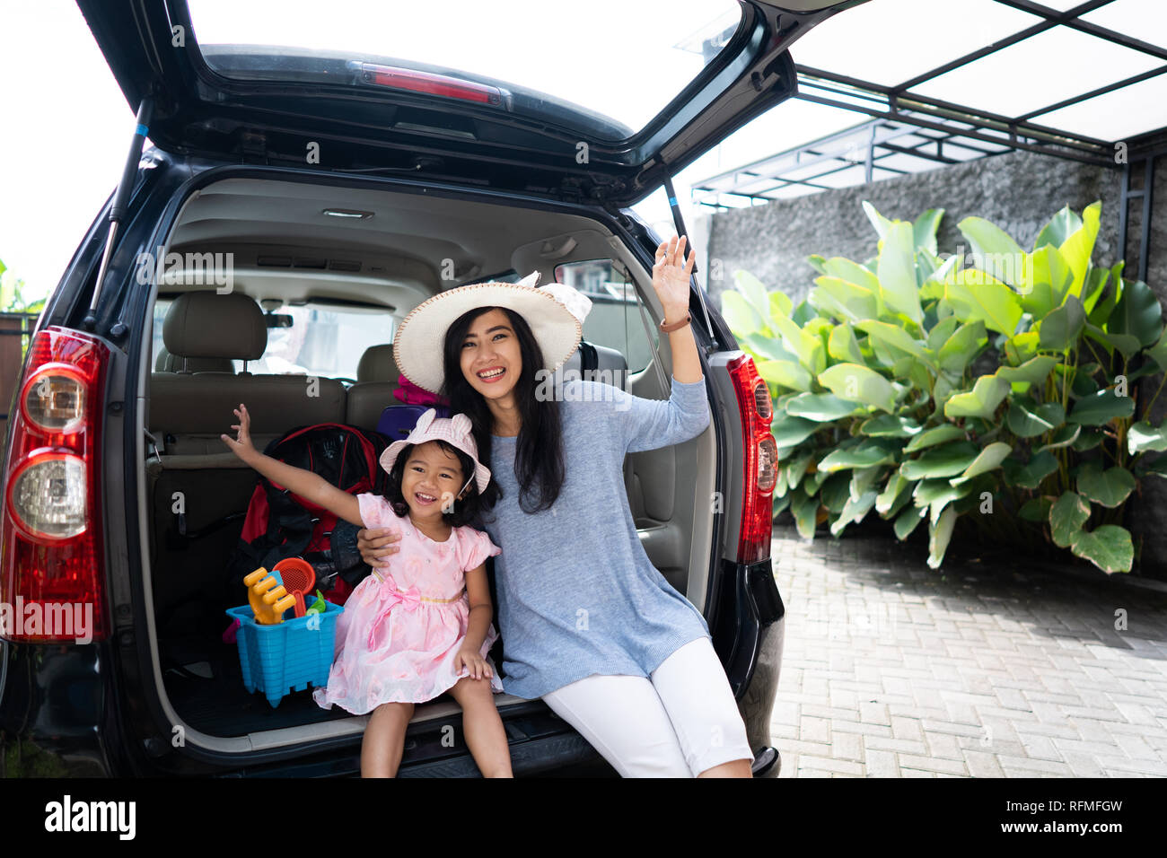 mother and child sitting in the car trunk Stock Photo - Alamy