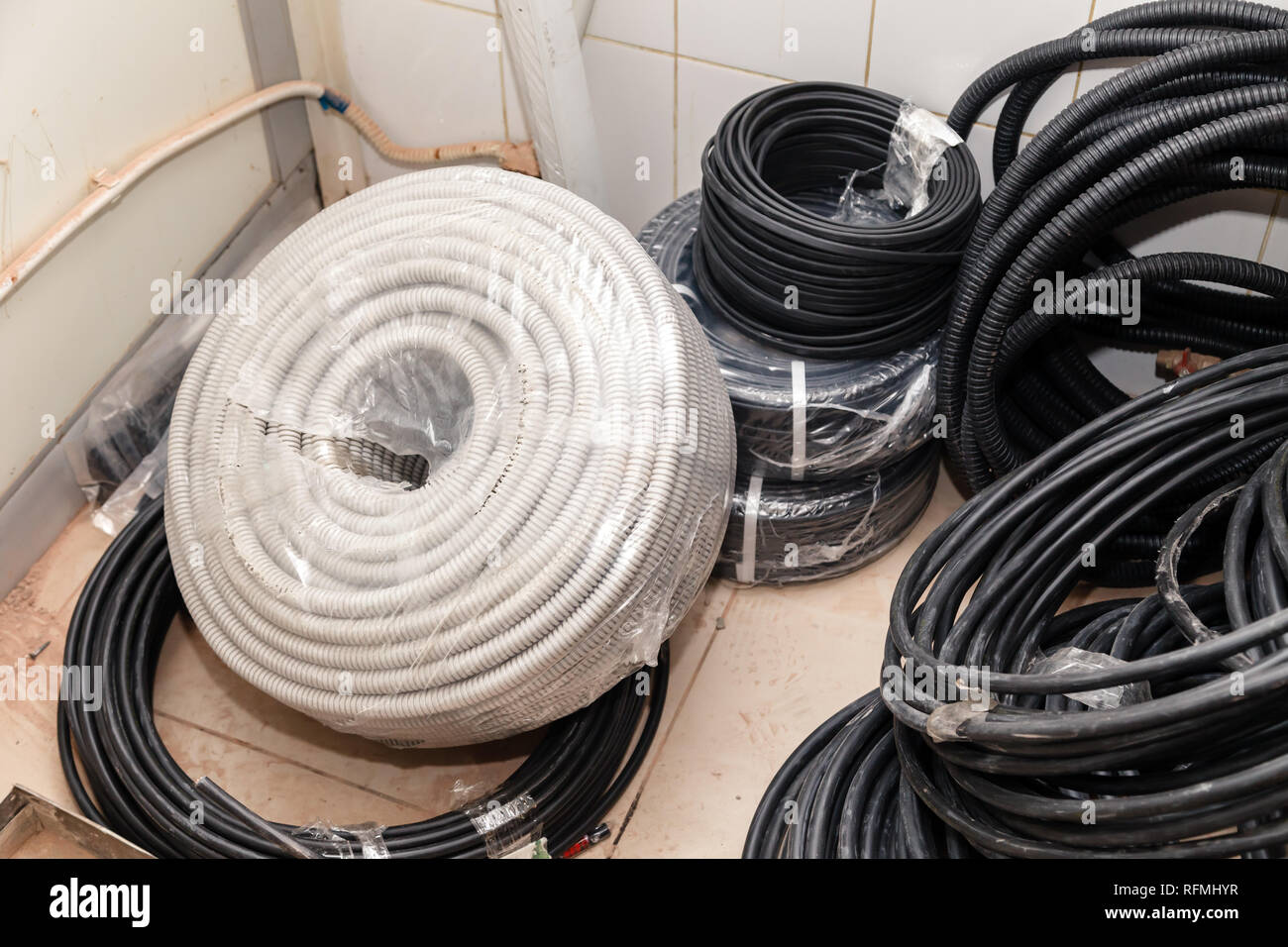 Electrical cable, black wires, grey insulation construction debris on