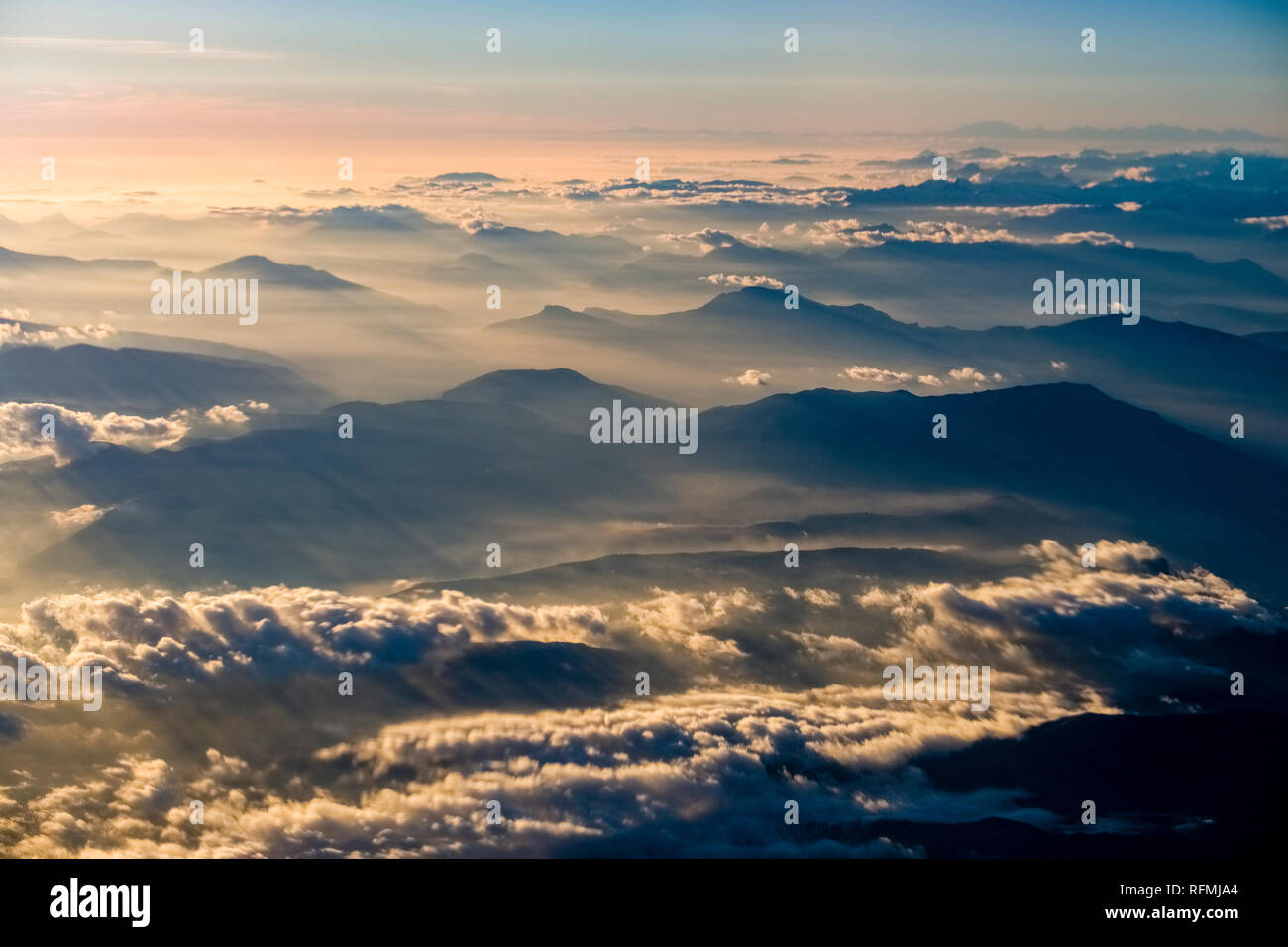 Aerial view from an aeroplane on the summits and foggy valleys of the Alps Stock Photo