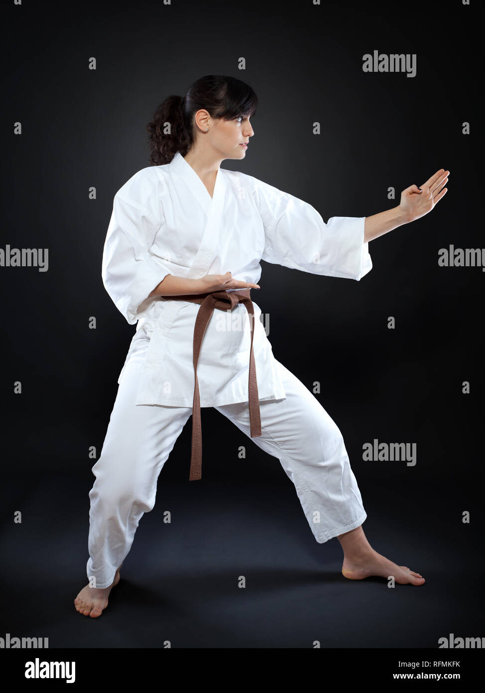 Karate woman in doing  pose on black background Stock Photo