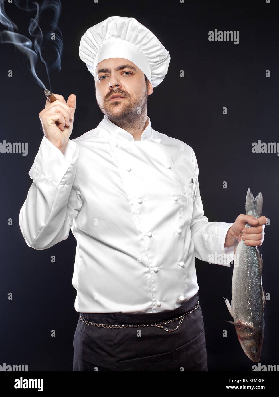 Young handsome chef with sea bass fish smoking cigar Stock Photo Alamy
