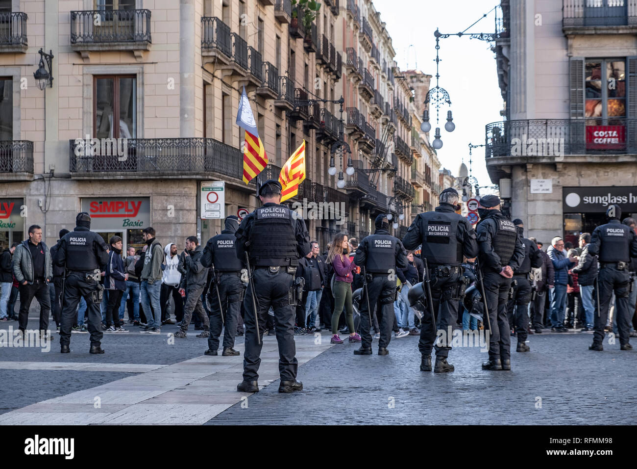 Police officers are seen in front of anti-fascist protesters during the demonstration. Only a few followers have attended to the call of the ultra-right ‘We Recover Spain-National Identity Front’ that was intended to celebrate the 80th anniversary of the entry of Francoist troops in Barcelona that ended the Spanish Civil War. Antifascists occupied the Plaza Sant Jaume for one hour where it was intended to celebrate the commemoration. Finally the police intervened to stop the anti-fascist protest. Stock Photo