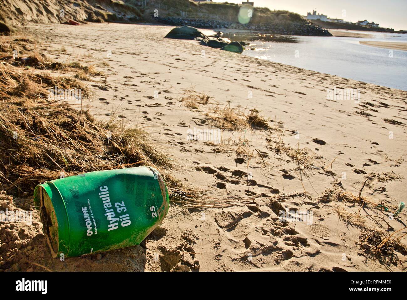 Plastic oil drum waste and pollution washed up on a beach in Rhosneigr, Anglesey, North Wales, UK Stock Photo