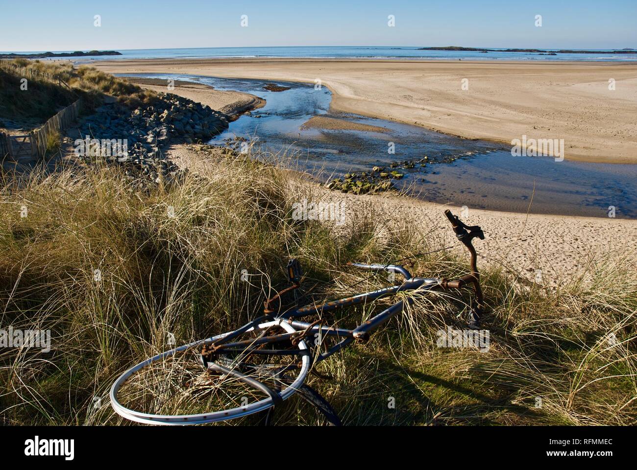 A broken bicycle discarded on a beautiful sandy beach in Rhosneigr, Anglesey, North Wales, UK Stock Photo