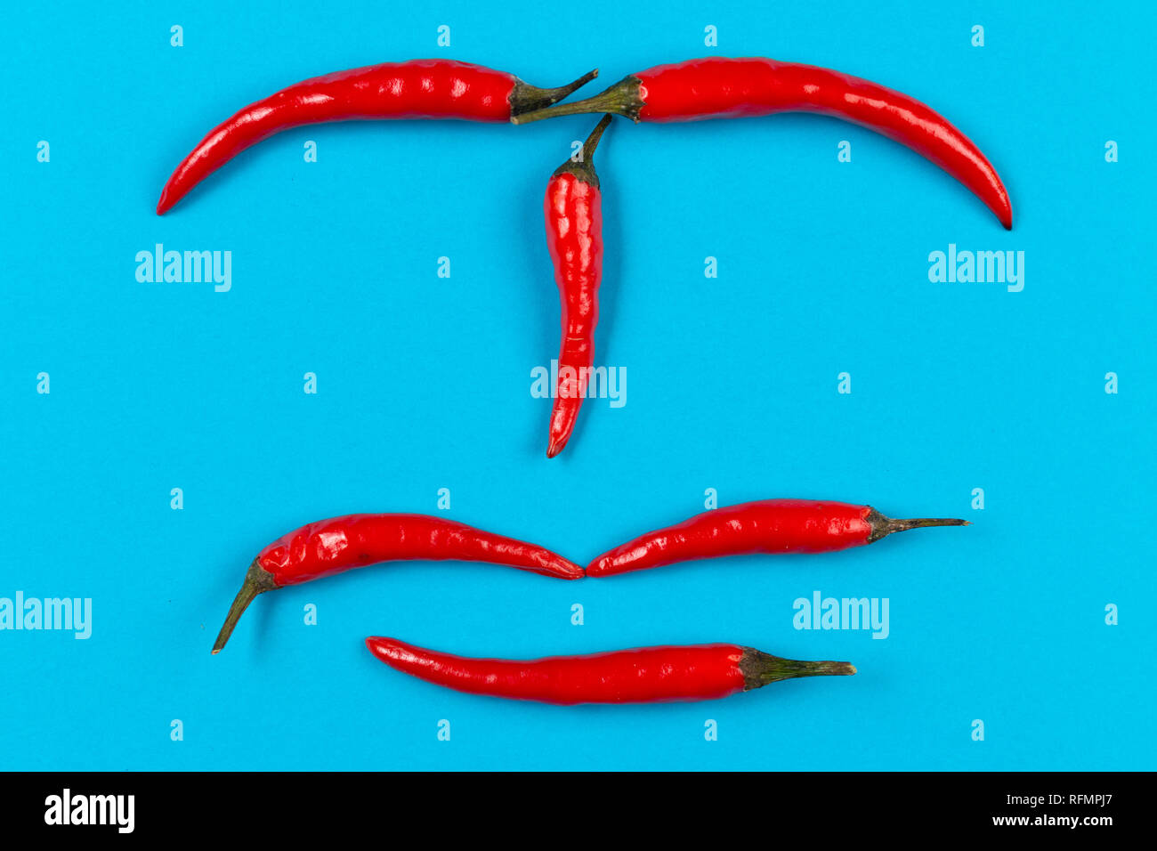 red chili pepper face on blue background Stock Photo Alamy