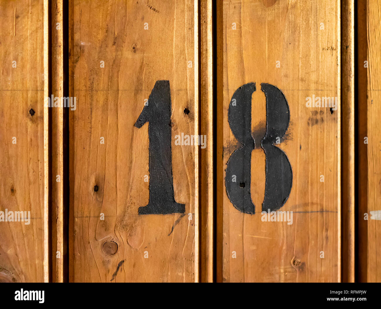 number 18 on door of storage room for tenants in century-old apartment building in stockholm Stock Photo