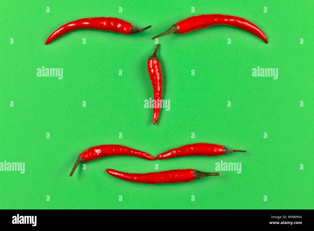 red chili pepper face on green background Stock Photo Alamy