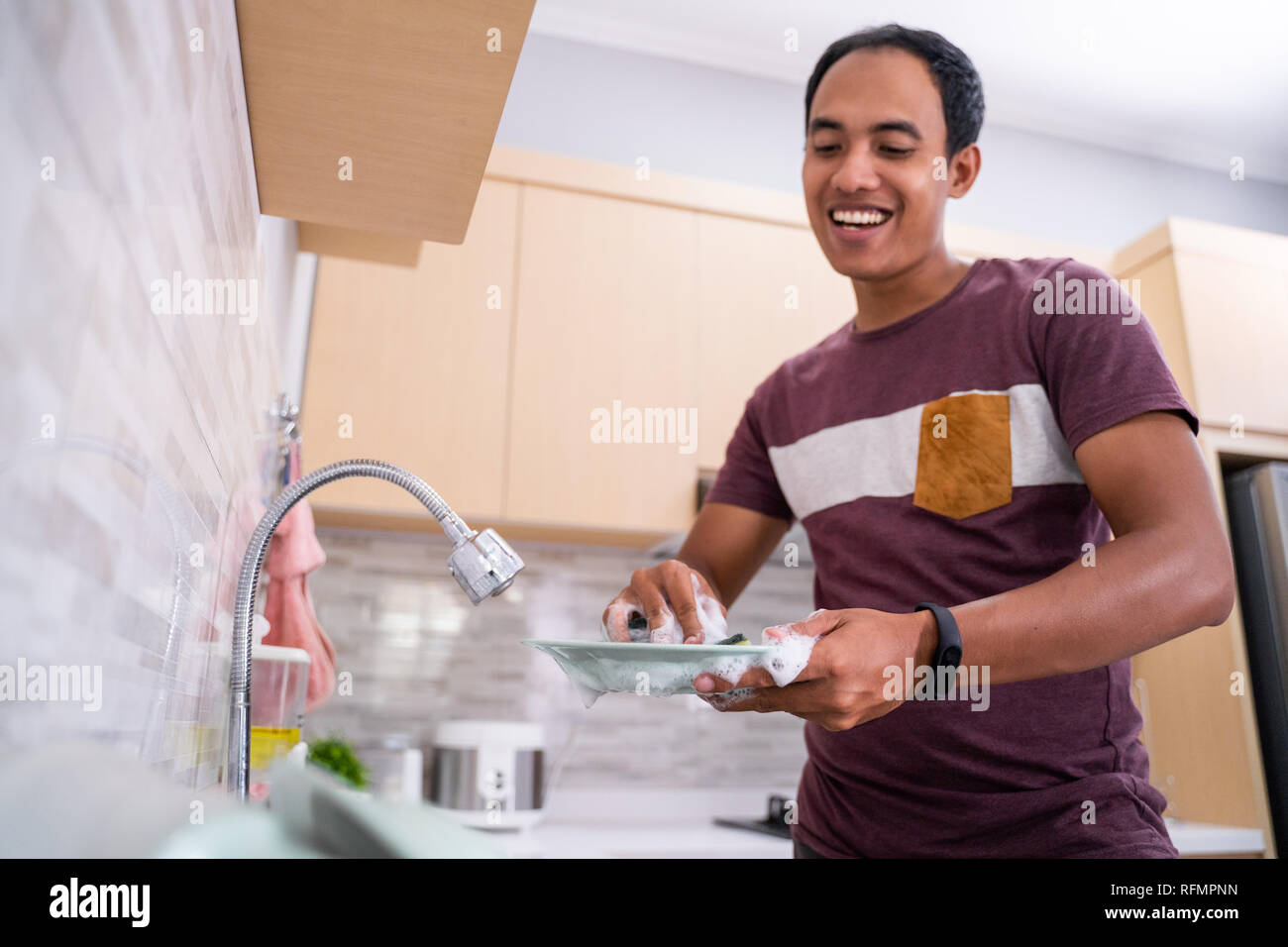 husband washing dish in the kitchen sink Stock Photo Alamy