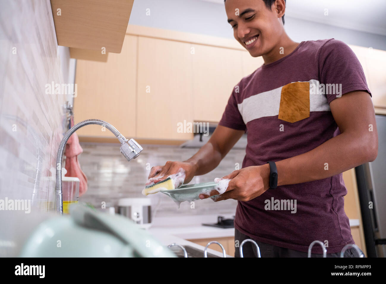 https://c8.alamy.com/comp/RFMPP3/husband-washing-dish-in-the-kitchen-sink-RFMPP3.jpg