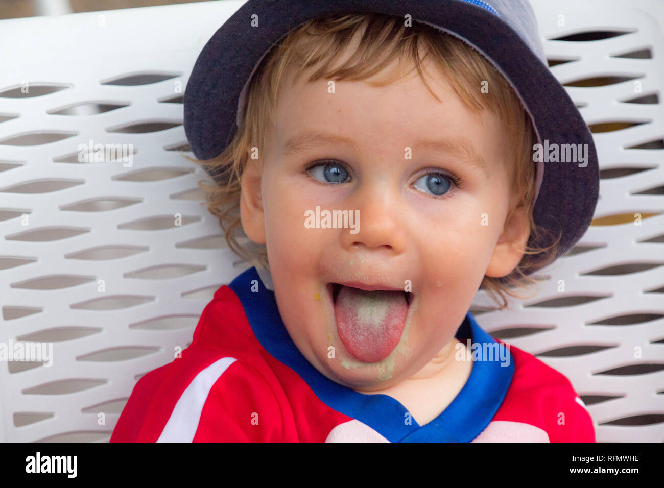 A portrait of a young boy showing tongue after having a delicious pistachio ice cream Stock Photo