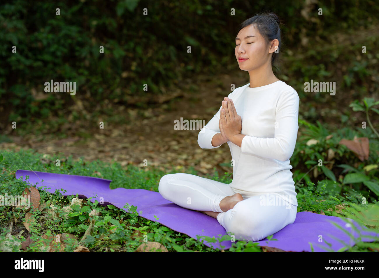 Beautiful girls are playing yoga at the park. Among the natural ...