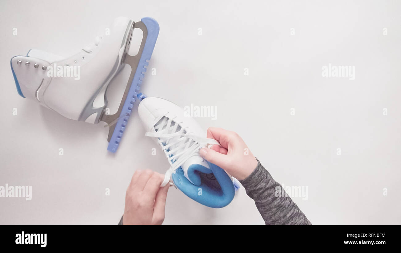 Flat lay. Lacing new white figure skates with white laces Stock Photo
