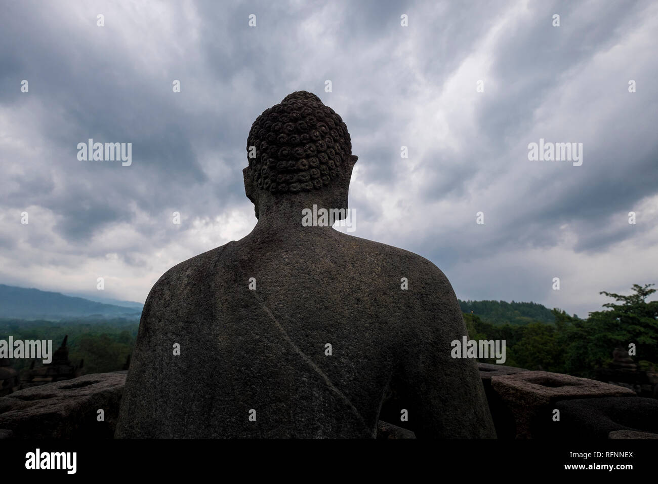 Buddha gazing out under a moody sky at Borobudur temple in Java, Indonesia. Stock Photo