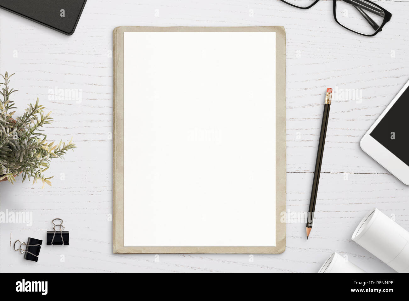 Empty paper mockup, on old folder, white wooden work desk. Top view, flat lay. Stock Photo