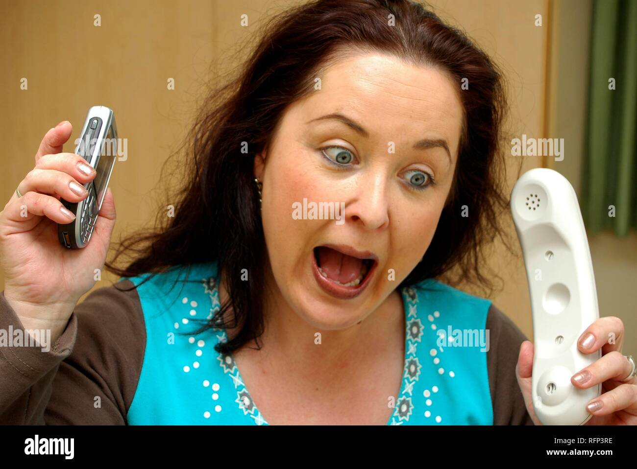 Stressed woman with telephones Stock Photo