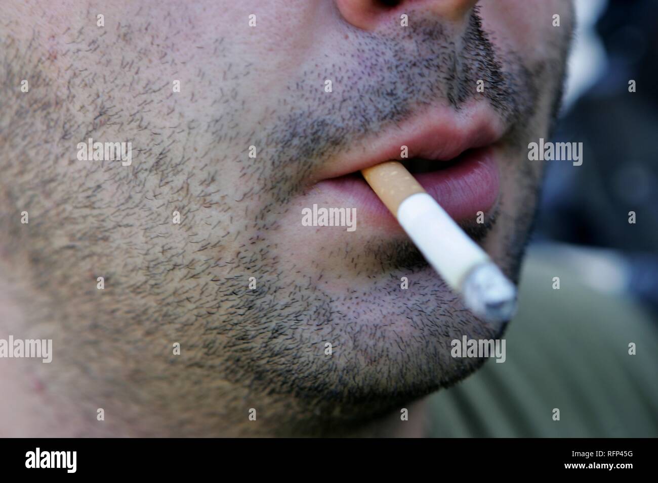 Unshaved man smoking a filter cigarette Stock Photo Alamy