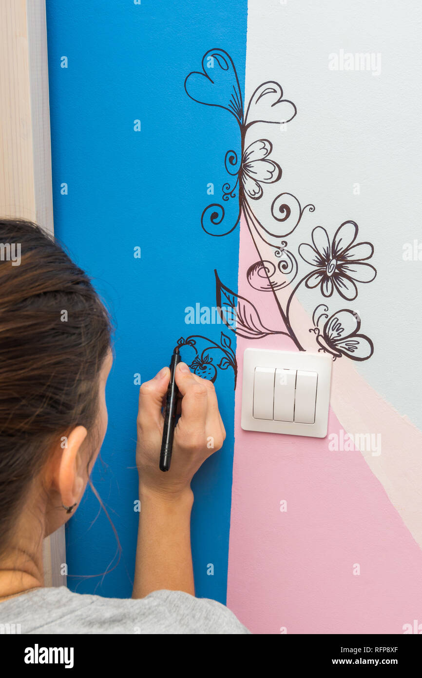 The artist paints a marker patterns on the walls of the children's room  Stock Photo - Alamy