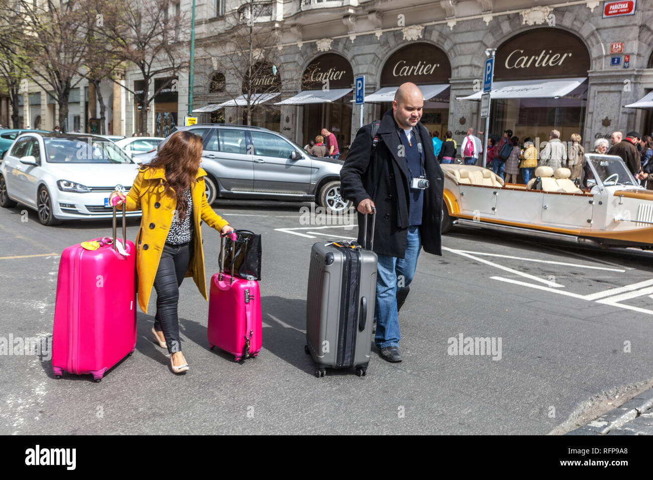 People suitcases in the city center, Parizska Street Prague, Czech Republic Traveling woman with luggage Cartier shop background suitcase woman street Stock Photo