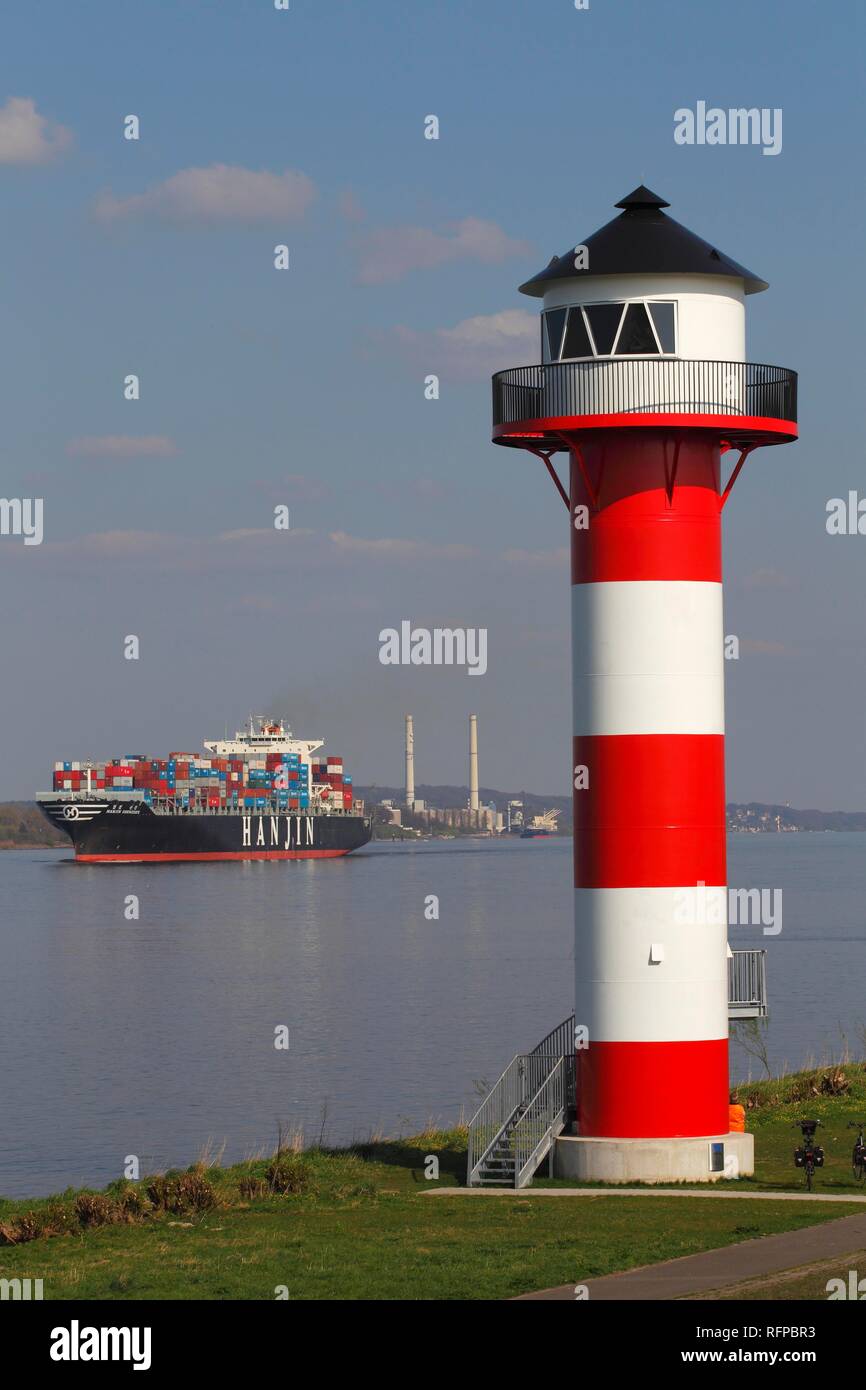 Container ship on the Elbe river passes lighthouse, front light Somfletherwisch, Lühe, Altes Land, district Stade, Lower Saxony Stock Photo