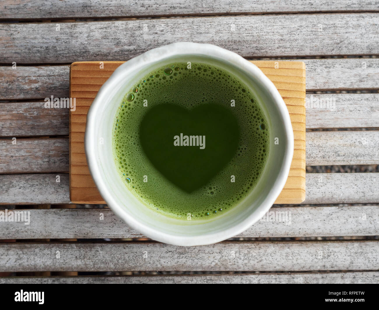 Top view of organic green tea matcha with heart shape in foam in white ...