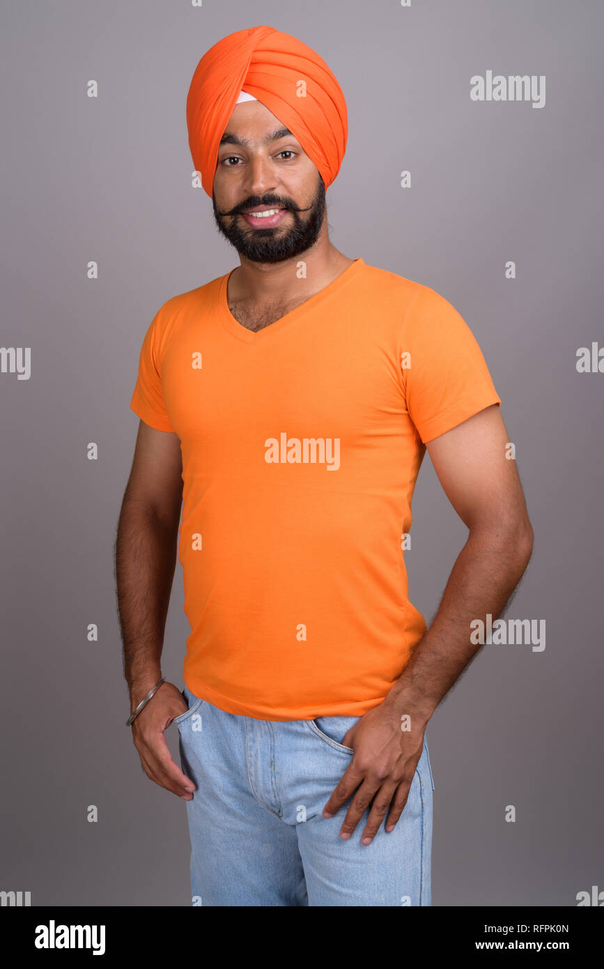 Indian Sikh man wearing turban and orange shirt Stock Photo
