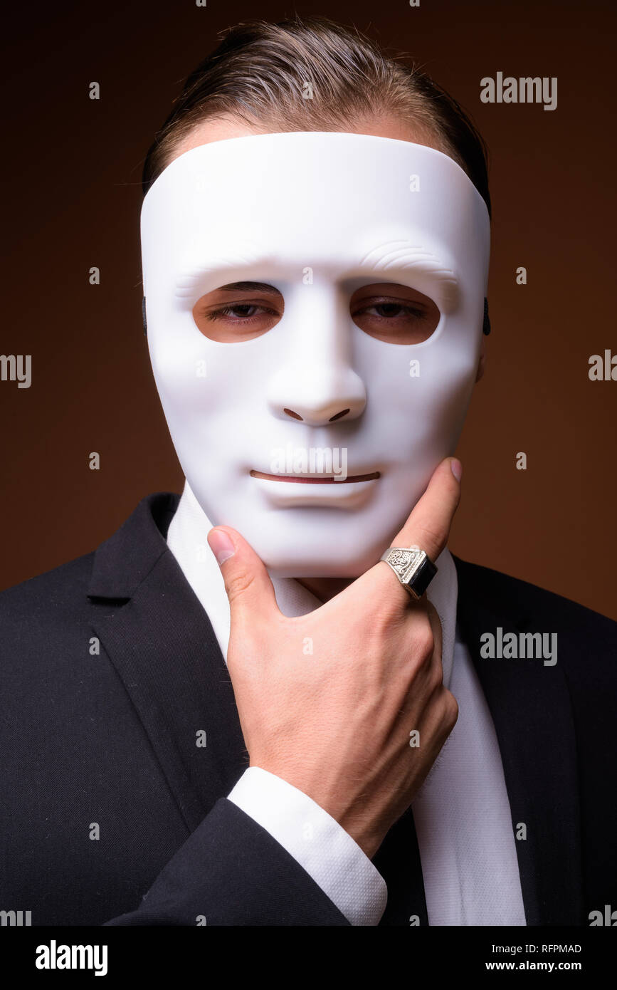 Portrait of young Caucasian businessman wearing white mask Stock Photo