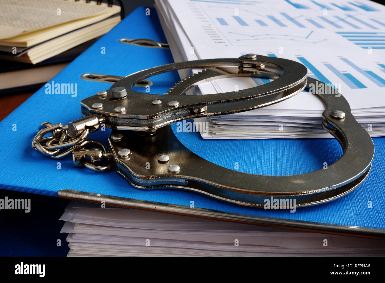 Tax evasion. Handcuffs and pile of financial papers. Stock Photo